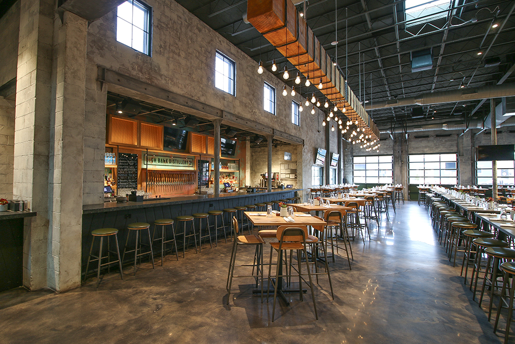 Large back lit bar with wood accents and high top tables