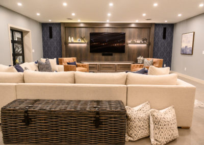 basement entertainment center with cream sectional couch and large wood trunk