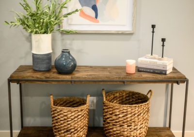 metal and wood credenza with wicker baskets and blue vases