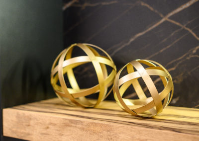 gold spheres on a wood floating shelf