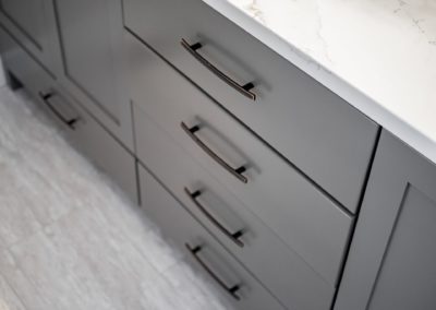 grey vanity, white countertop, dark handles