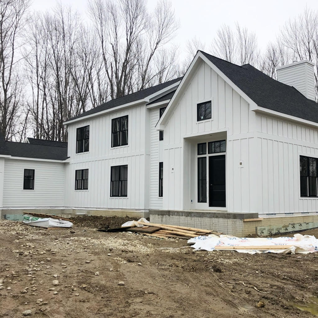 new construction of a home showing the finished home with siding and windows but no grass or landscaping