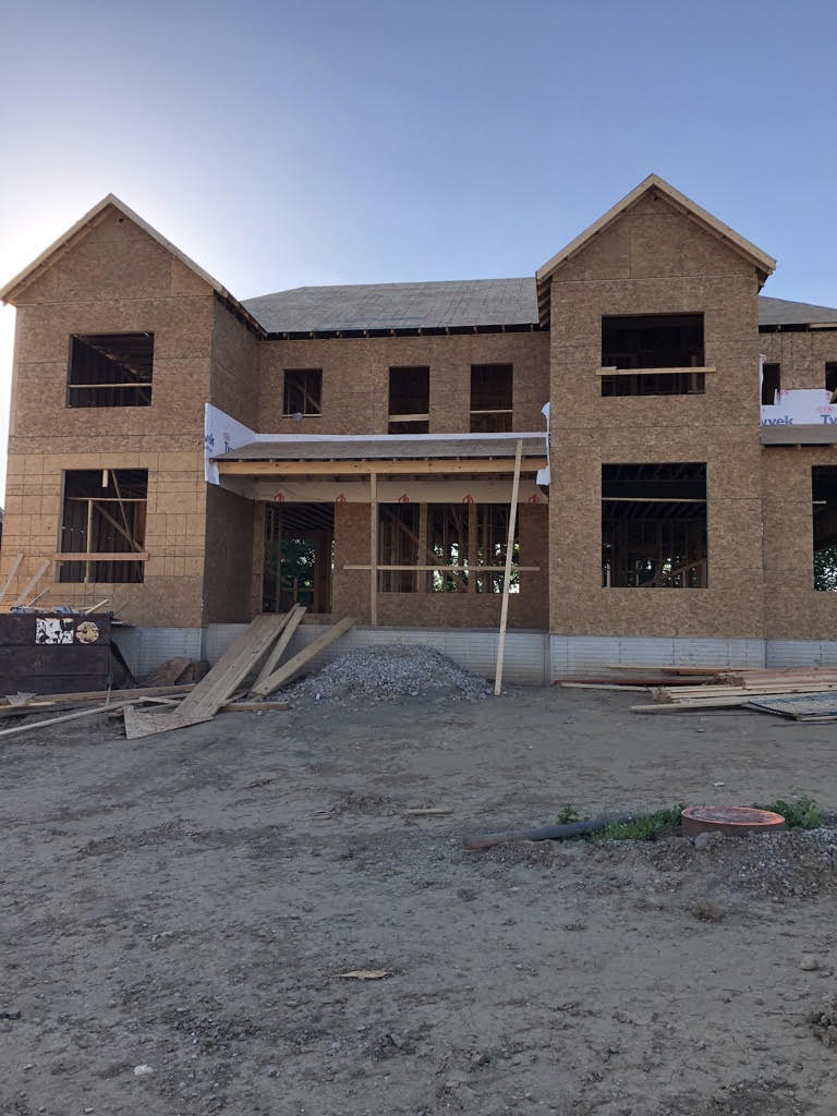 New construction of a home showing the exterior without siding and windows