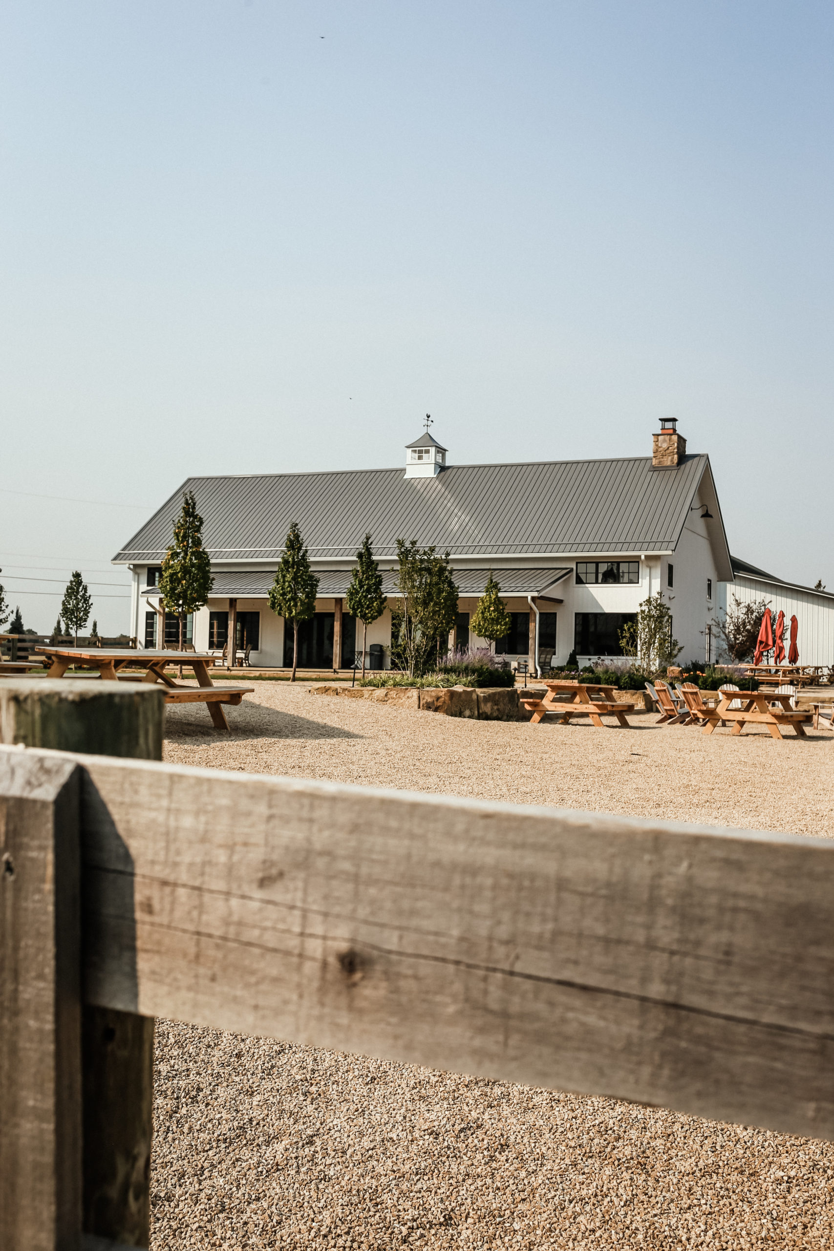 a view from the front fence of a white barn like brewery