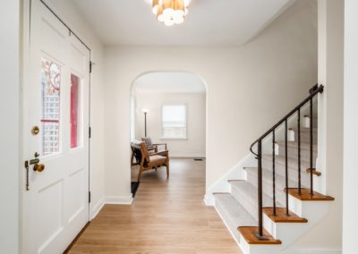 foyer with staircase runner and brushed gold light fixture