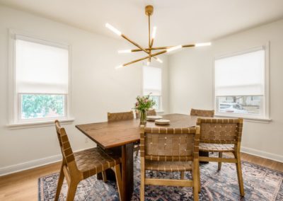 dining table with woven leather back chairs and brass light fixture