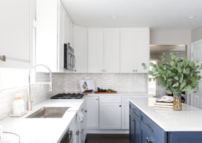 White Cabinetry Kitchen Remodel with Blue Island with Round Chandelier