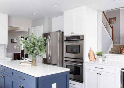 White Cabinetry Kitchen Remodel with Blue Island with Round Chandelier, stainless steel appliances, double oven