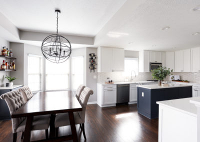 White Cabinetry Kitchen Remodel with Blue Island with Round Chandelier