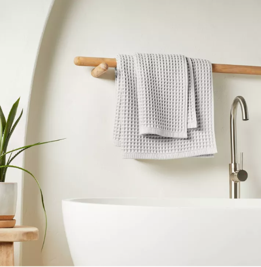 Gray waffle weave bath towel styled in bathroom with plant and decor