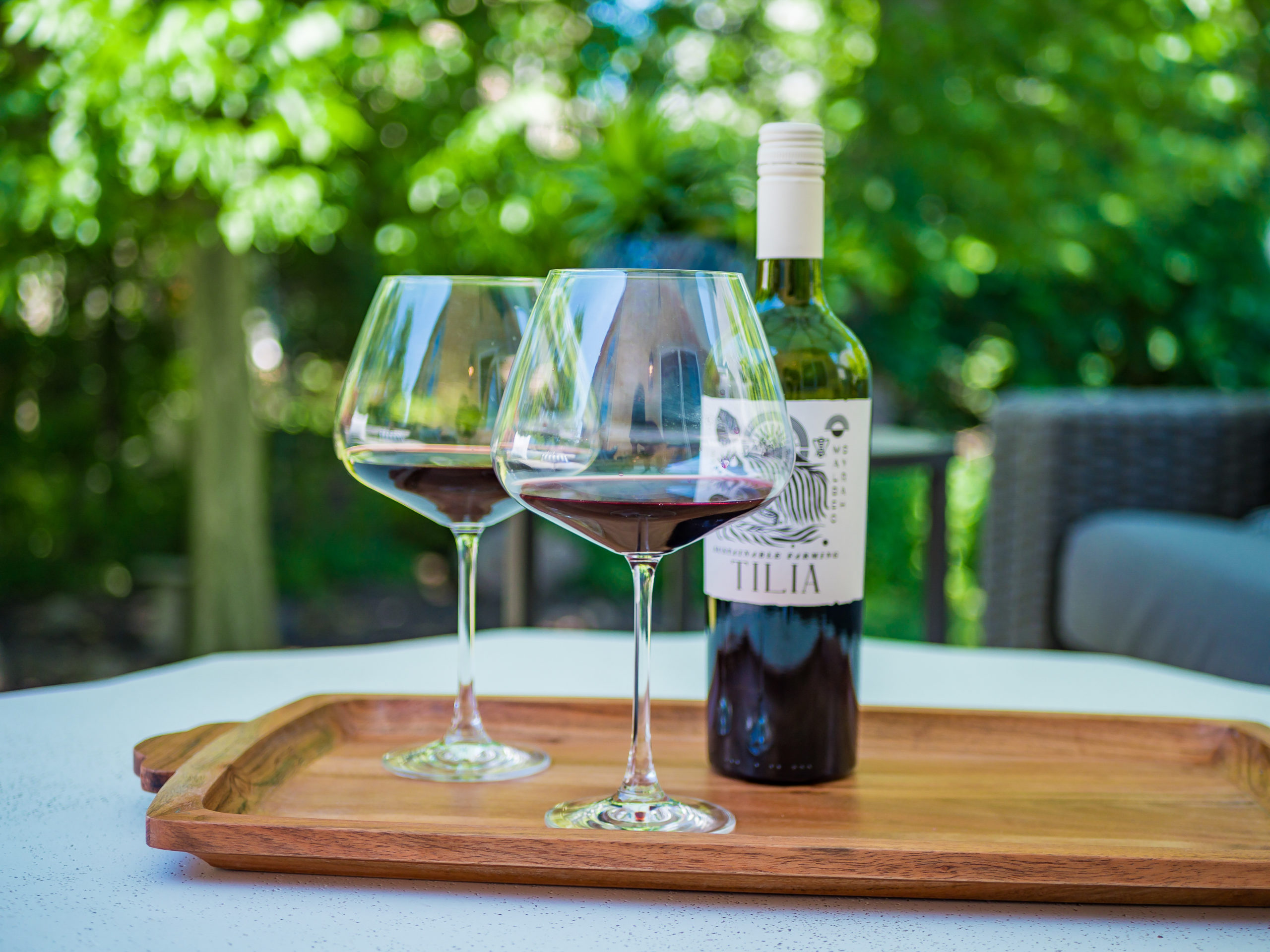 Wine tray on a modern multilevel patio with outdoor furniture