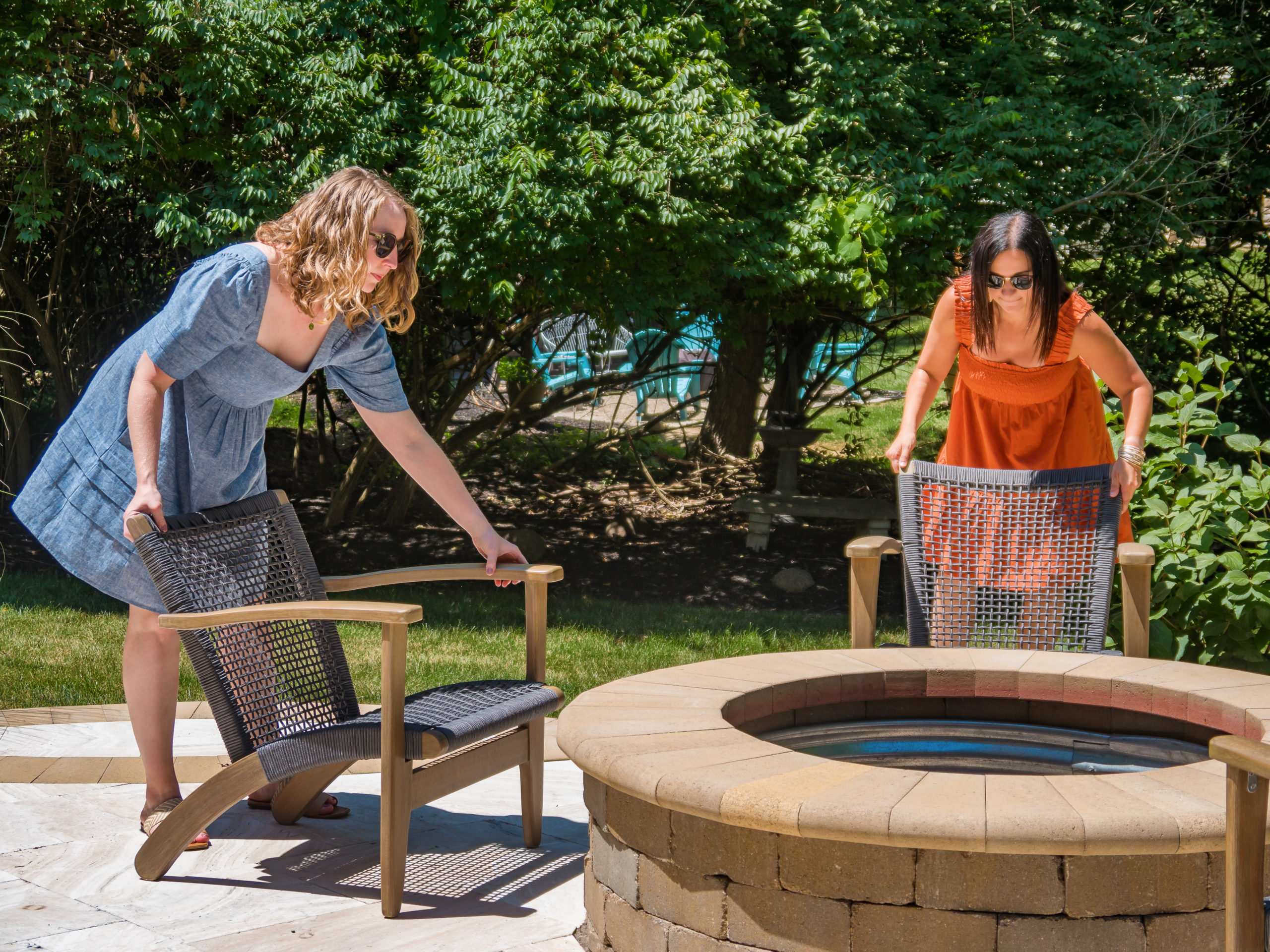 Two interior designers setting up a clients multilevel patio with new accents and decor