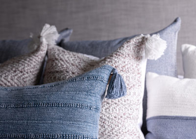 Blue, gray and tan throw pillows on bed